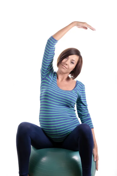Mujer embarazada en la pelota de ejercicio — Foto de Stock