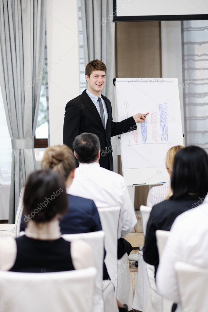 Young business man giving a presentation on conference