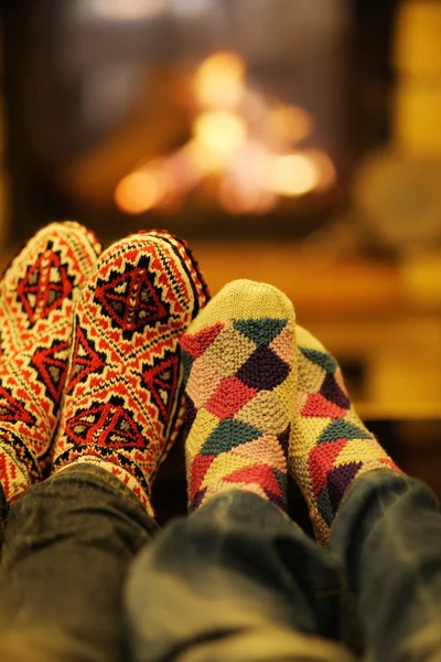 Pareja romántica joven sentada en el sofá delante de la chimenea en casa —  Fotos de Stock