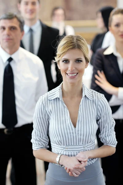 业务妇人站在与她在会议上的工作人员 — 图库照片
