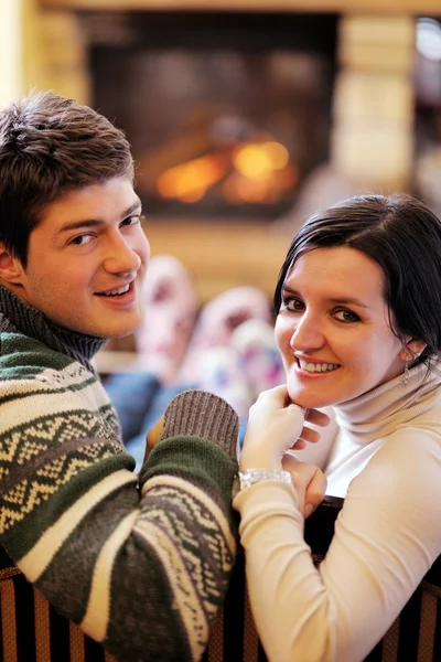 Young romantic couple relax on sofa in front of fireplace at hom — Stock Photo, Image