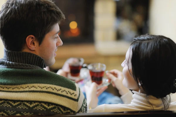 Unga romantiska par sitter och kopplar av framför öppna spisen hemma — Stockfoto