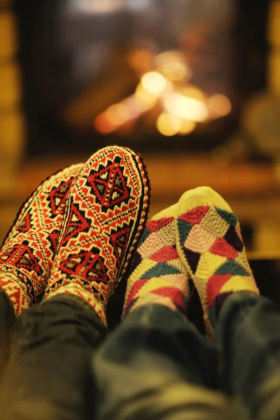 Joven pareja romántica sentada y relajada frente a la chimenea en casa —  Fotos de Stock
