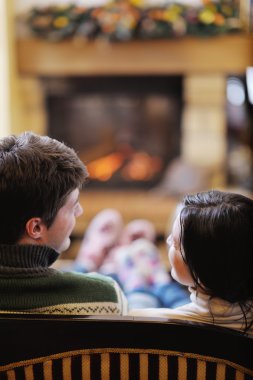 Genç Romantik Çift oturma ve şöminenin önünde evde rahatlatıcı