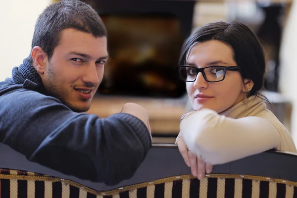 Młoda para romantyczny siedzący i relaks przy kominku w domu — Zdjęcie stockowe