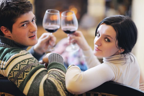 Unga romantiska par sitter och kopplar av framför öppna spisen hemma — Stockfoto