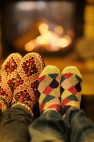 浪漫的年轻夫妇坐和舒舒服服坐着在家里的壁炉 — 图库照片