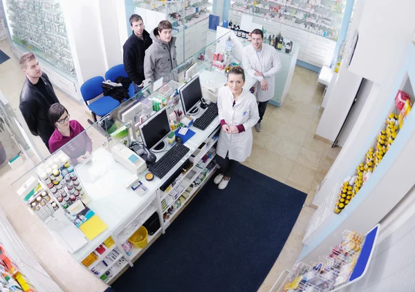 Aptekarz sugerujący kupcowi lekarstwo w aptece — Zdjęcie stockowe