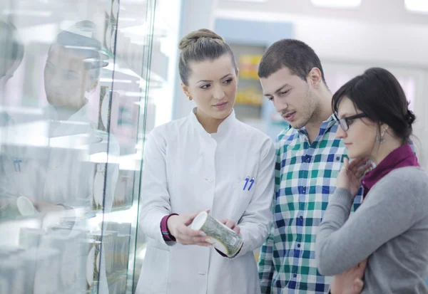 Gyógyszerész orvosi gyógyszert javasol a vevőnek a gyógyszertárban — Stock Fotó