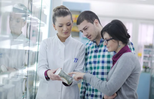 Farmacéutico sugiriendo medicamento médico al comprador en farmacia — Foto de Stock