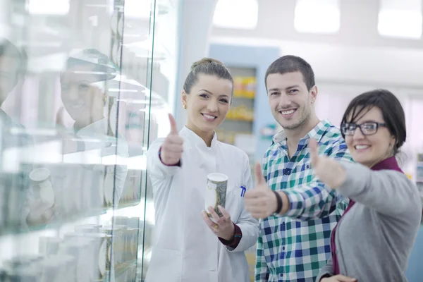 Pharmacist suggesting medical drug to buyer in pharmacy drugstore — Stock Photo, Image