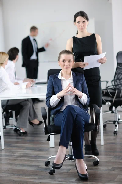 Affärskvinna med hennes personal i bakgrunden — Stockfoto