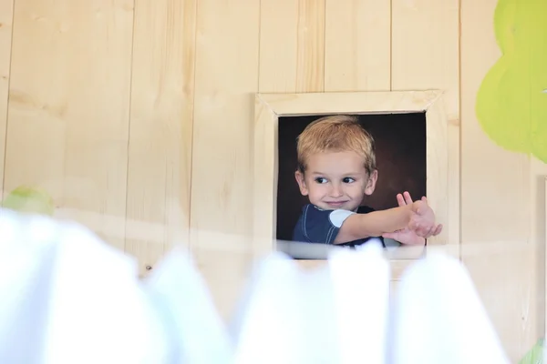 Niño feliz en una ventana — Foto de Stock