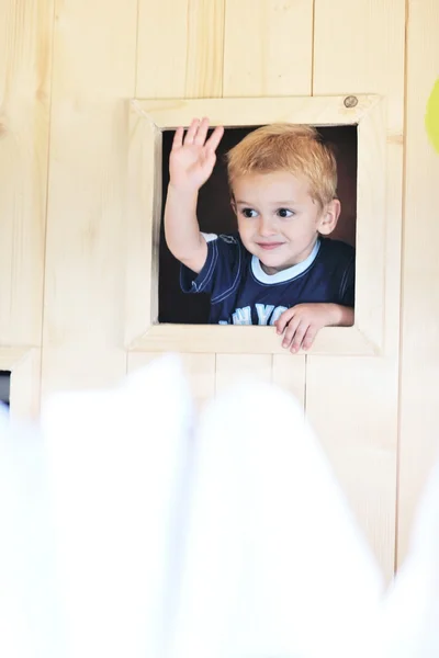 Niño feliz en una ventana —  Fotos de Stock