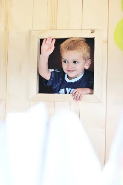 Gelukkig kind in een venster — Stockfoto