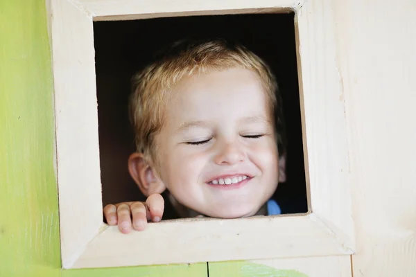 Criança feliz em uma janela — Fotografia de Stock