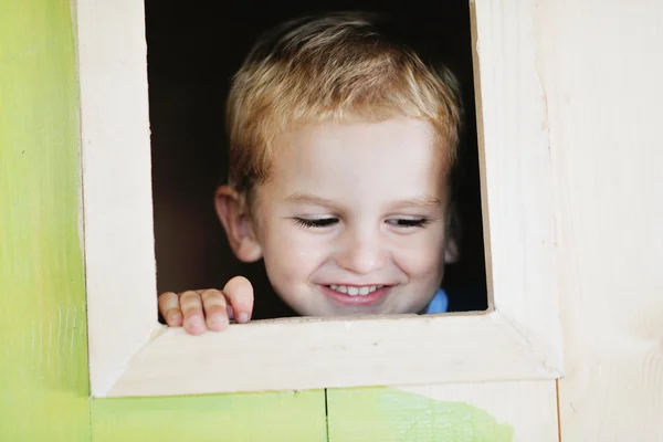 Niño feliz en una ventana —  Fotos de Stock
