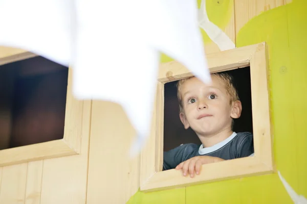 Lyckligt barn i ett fönster — Stockfoto
