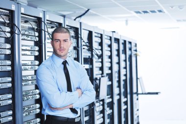 Young it engeneer in datacenter server room clipart