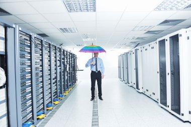 Businessman hold umbrella in server room clipart