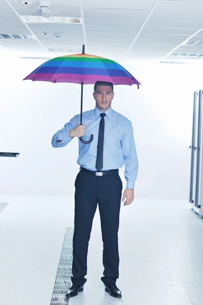 Geschäftsmann hält Regenschirm im Serverraum — Stockfoto