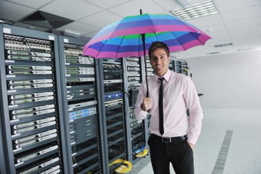 Businessman hold umbrella in server room clipart