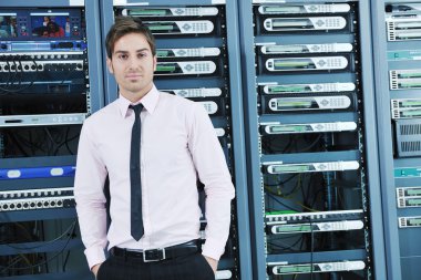 Young it engeneer in datacenter server room clipart