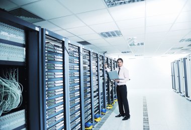 Young it engeneer in datacenter server room clipart