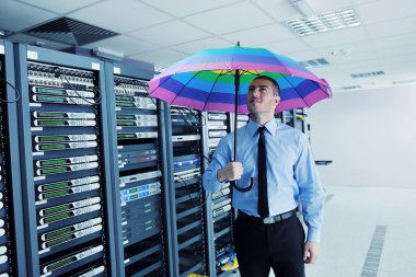 Businessman hold umbrella in server room clipart