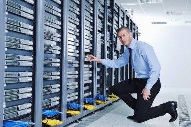 Young it engeneer in datacenter server room clipart