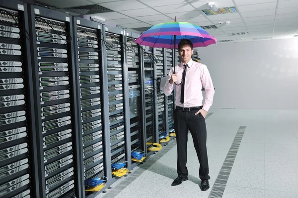 Podnikatel drží deštník v serverové místnosti — Stock fotografie