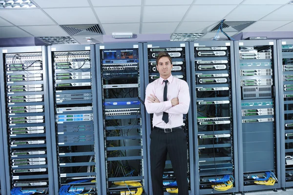 Joven engeneer en la sala de servidores del centro de datos — Foto de Stock