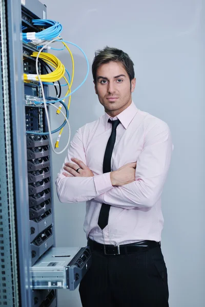 Joven engeneer en la sala de servidores del centro de datos — Foto de Stock