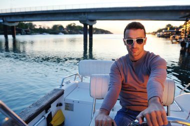 Portrait of happy young man on boat clipart