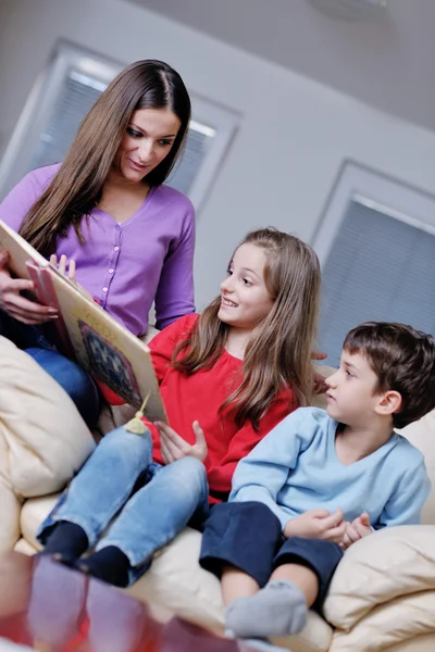 Genç anne oyun onların evde çocuklar ve kitap okumak — Stok fotoğraf