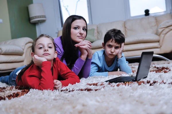 Joven mamá jugar con sus hijos en casa y leer libro —  Fotos de Stock