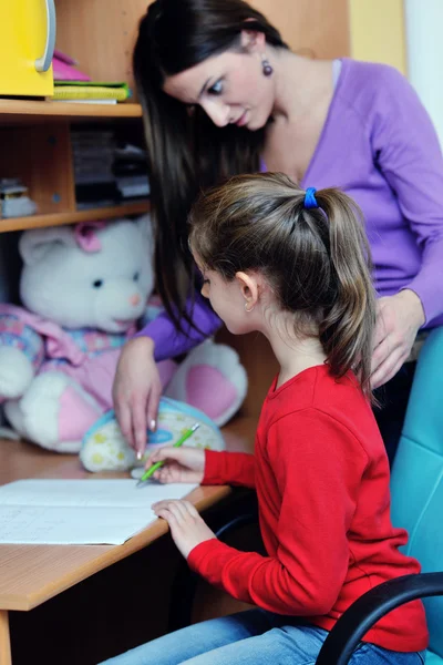 Мама и девочка делают домашнее задание дома — стоковое фото