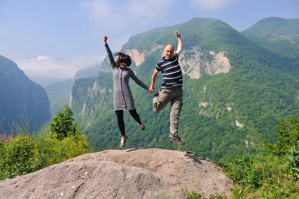 Счастливая молодая пара, прыгающая в воздух — стоковое фото