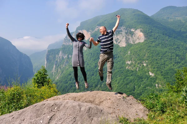 Feliz joven pareja saltando en el aire — Foto de Stock