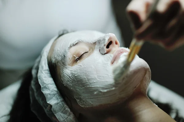 Kvinna med ansiktsmask i kosmetiska studio — Stockfoto