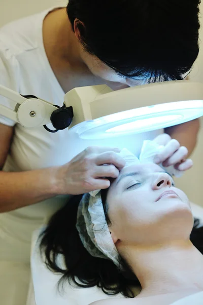 Kvinna med ansiktsmask i kosmetiska studio — Stockfoto