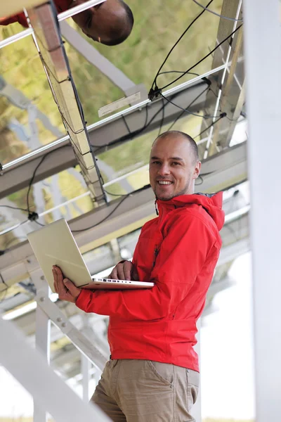 Engineer using laptop at solar panels plant field — Stock Photo, Image