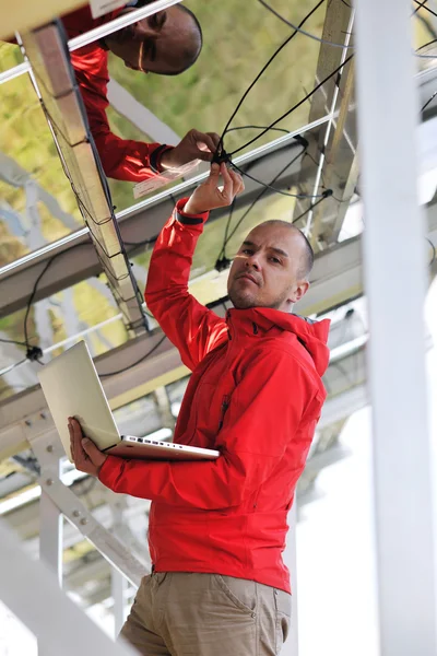 Engineer using laptop at solar panels plant field — Stock Photo, Image