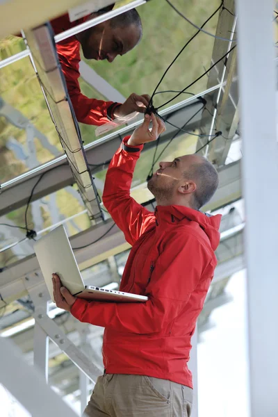 Μηχανικός που χρησιμοποιεί το lap-top στο πεδίο εγκαταστάσεων ηλιακών πινάκων — Φωτογραφία Αρχείου
