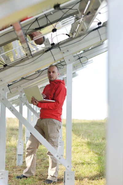 Laptopot használó mérnök a napelemes üzemcsarnokban — Stock Fotó