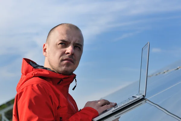Ingeniero que usa el ordenador portátil en el campo de la planta de paneles solares —  Fotos de Stock