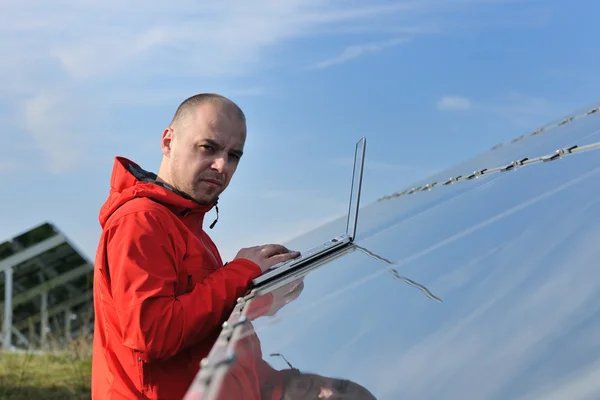 Инженер с помощью ноутбука на солнечных панелях — стоковое фото