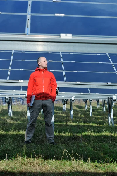Engenheiro usando laptop no campo de planta de painéis solares — Fotografia de Stock