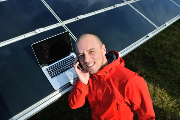 Inżynier korzystający z laptopa w polu elektrociepłowni paneli słonecznych — Zdjęcie stockowe