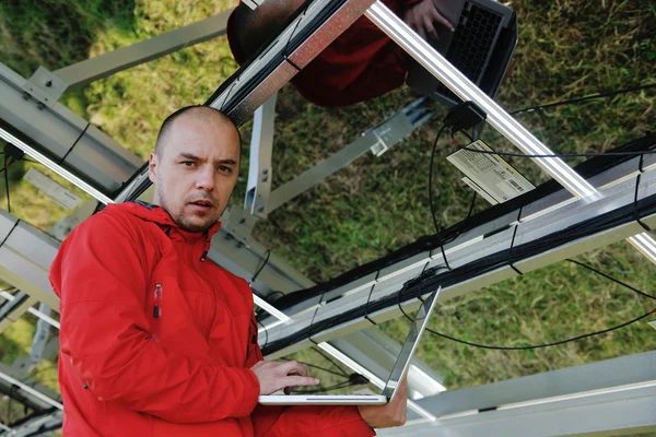 Engineer using laptop at solar panels plant field — Stock Photo, Image